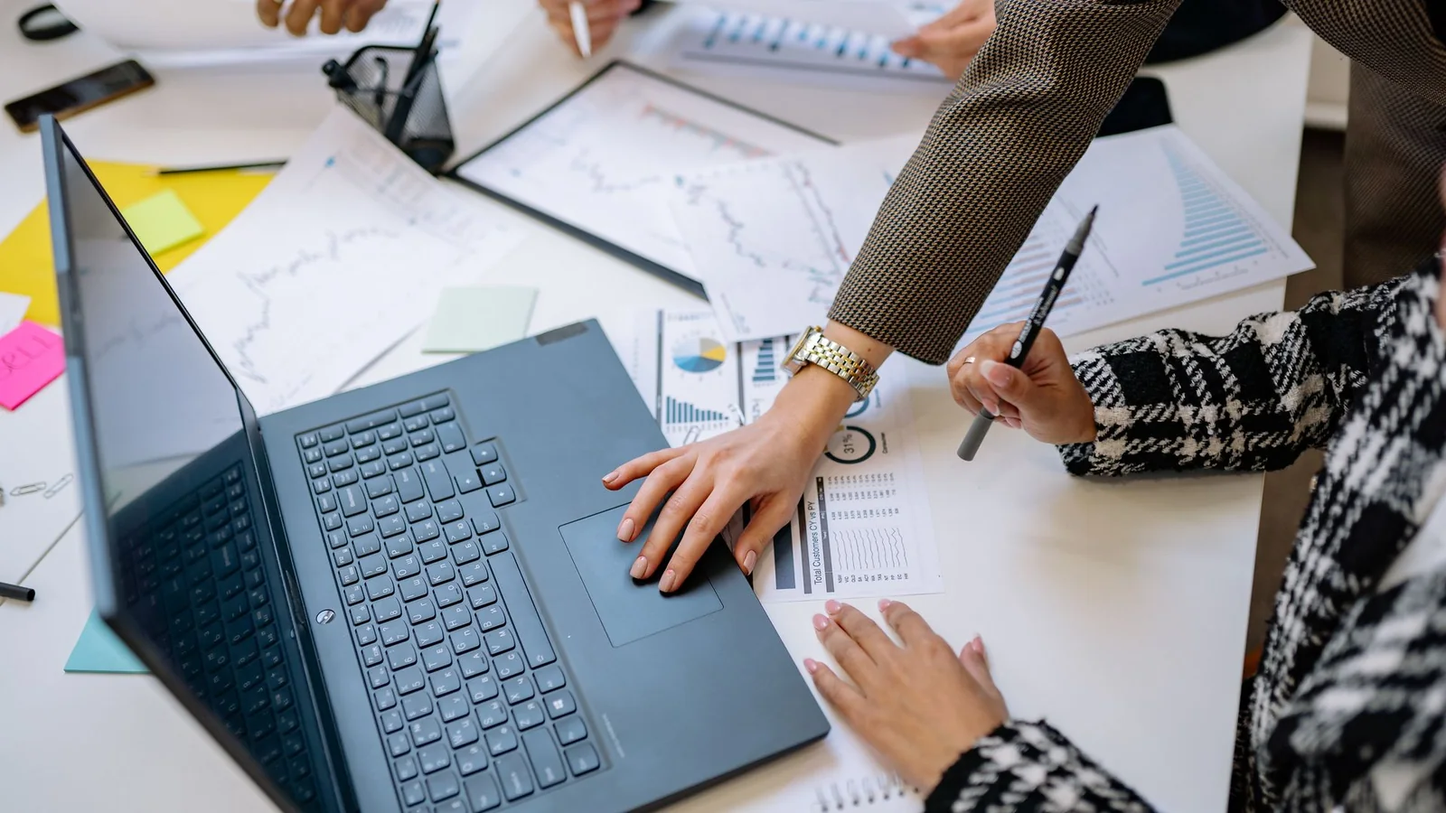 Equipe analisando relatórios e gráficos para comparar a Cobrativa com a Assertiva