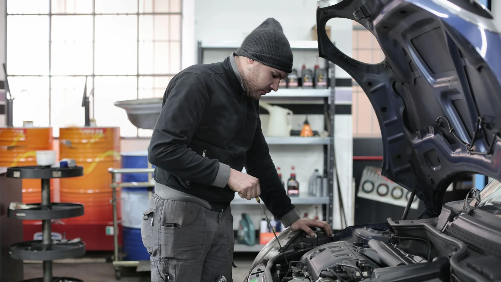 Mecânico examinando o motor de um carro para representar a comparação de consultas veiculares