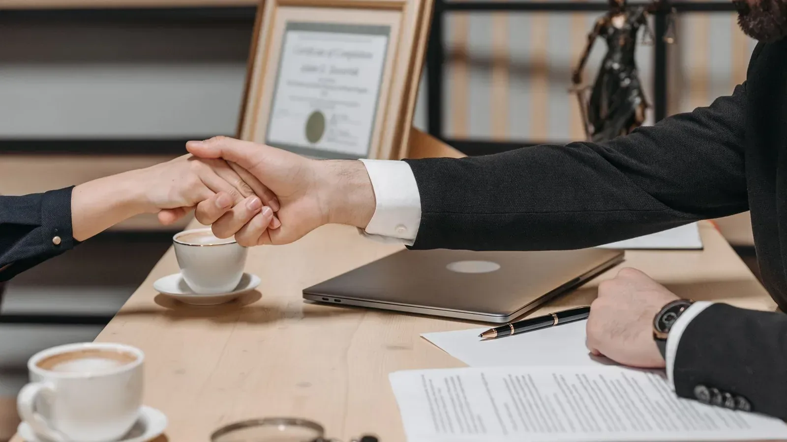 Aperto de mãos sobre contrato durante a contratação de uma plataforma de cobrança