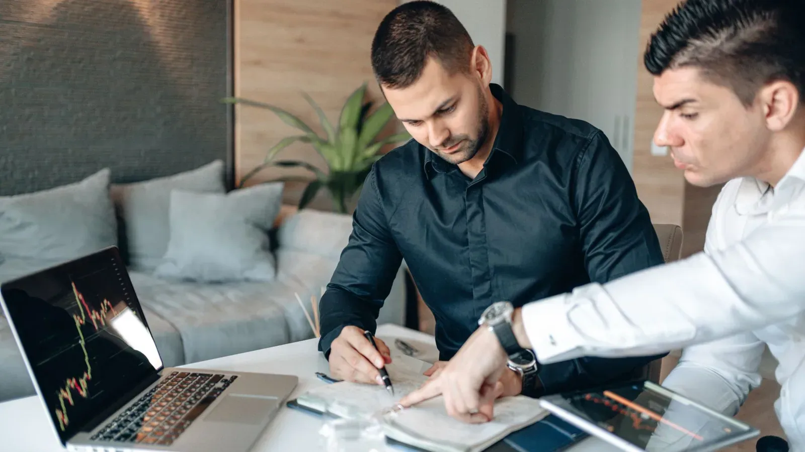 Profissionais analisando documentos e gráficos antes de aprovar um negócio entre empresas